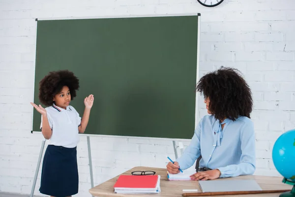 African American Pupil Showing Shrug Gesture Teacher Chalkboard — Stock Photo, Image