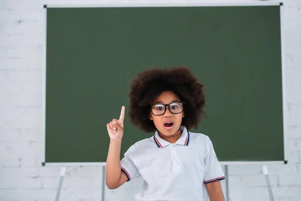 Astonished African American Pupil Having Idea Blurred Chalkboard Classroom — Stock Photo, Image
