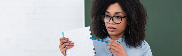 African American Teacher Pointing Notebook Classroom Banner — Stock Photo, Image