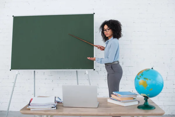 Profesor Afroamericano Apuntando Pizarra Durante Lección Línea Cerca Computadora Portátil — Foto de Stock