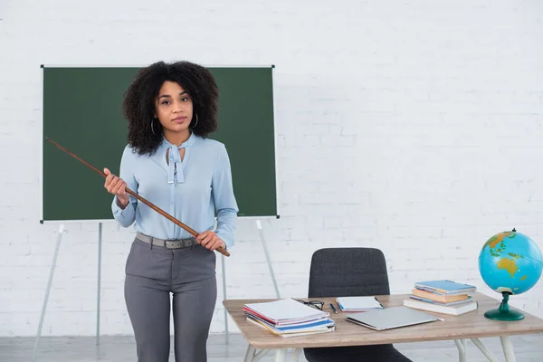 Insegnante Afroamericano Con Puntatore Piedi Vicino Tavolo Lavoro Classe — Foto Stock