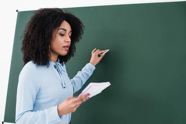 African American Teacher Notebook Writing Chalkboard Classroom — Stock Photo, Image