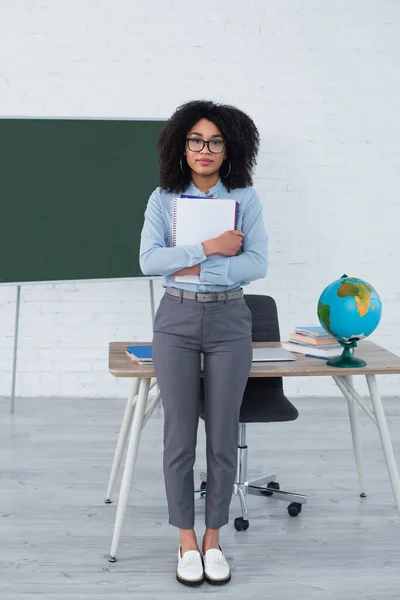 Afrikansk Amerikansk Lärare Glasögon Som Håller Anteckningsböcker Nära Laptop Och — Stockfoto