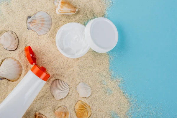 Top View Cosmetic Cream Sunscreen Seashells Sand Blue Surface — Stok Foto