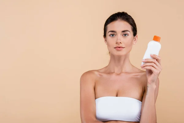 Brunette Woman Bottle Sunscreen Looking Camera Isolated Beige — Stockfoto