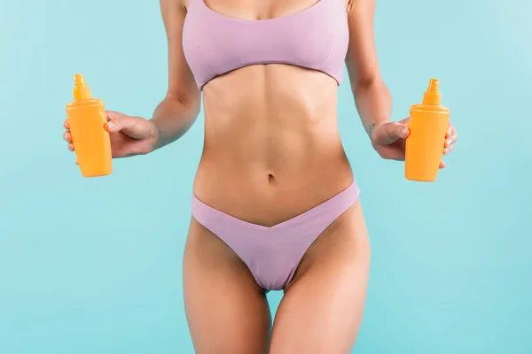 Cropped View Slim Woman Swimsuit Holding Orange Sunblock Bottles Isolated — Φωτογραφία Αρχείου
