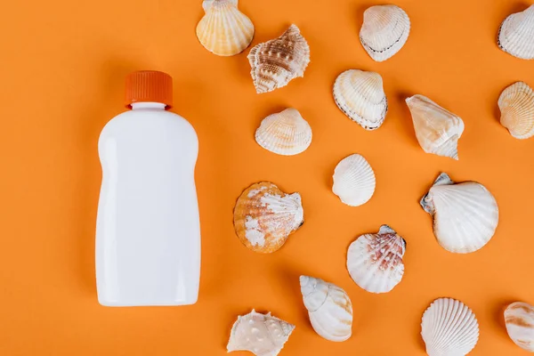 Top View Seashells White Bottle Sunscreen Orange Surface — Φωτογραφία Αρχείου