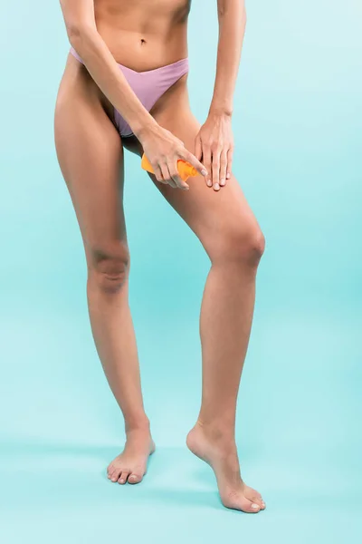 Cropped View Barefoot Woman Blue Background Applying Sunscreen Leg — Φωτογραφία Αρχείου