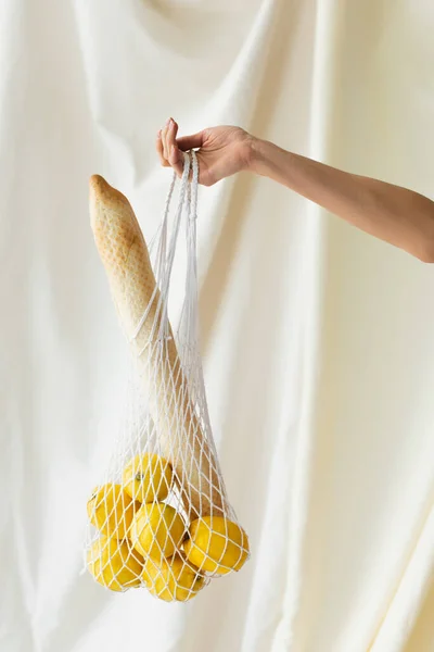 Cropped View Woman Holding Reusable String Bag Lemons Baguette White — Stock Photo, Image