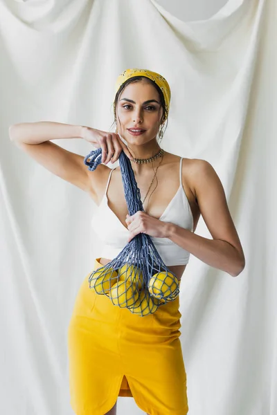 Happy Woman Yellow Headscarf Crop Top Holding String Bag Lemons — Stock Photo, Image