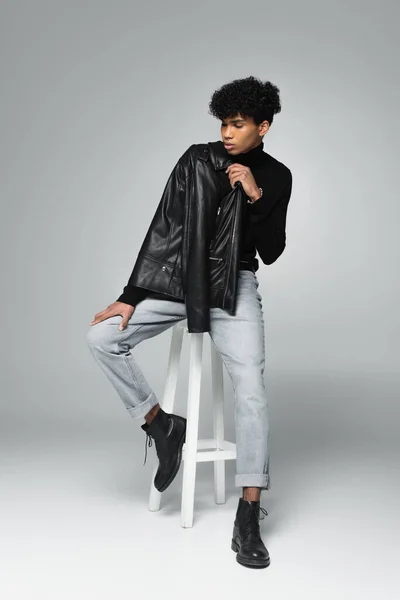 Молодий Афроамериканський Чоловік Модному Одязі Позує Високому Табуреті Сірому Фоні — стокове фото