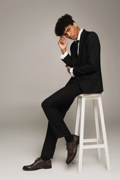 Junger Afrikanisch Amerikanischer Mann Schwarzen Anzug Sitzt Auf Weißem Hocker — Stockfoto
