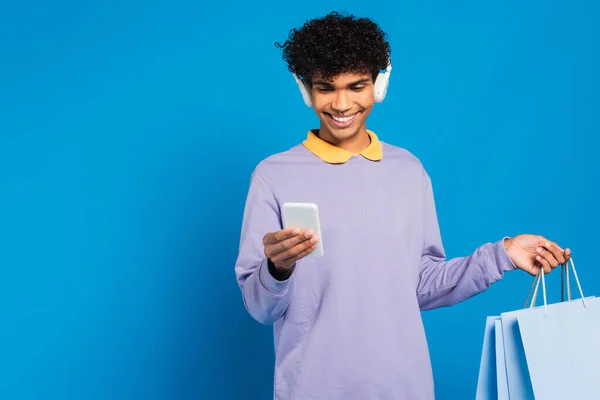 Glimlachende Afro Amerikaanse Man Koptelefoon Met Boodschappentassen Met Behulp Van — Stockfoto