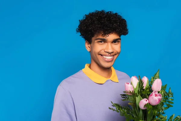 Веселий Афроамериканський Чоловік Рожевими Тюльпанами Посміхається Камеру Ізольовано Синьому — стокове фото