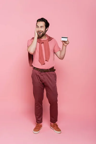 Spännande Man Håller Kreditkort Rosa Bakgrund — Stockfoto