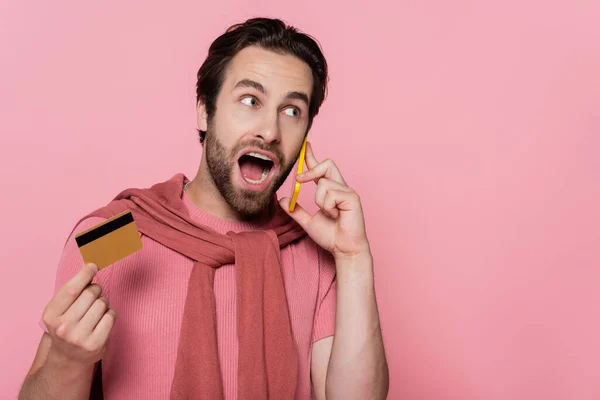 Hombre Sorprendido Hablando Teléfono Móvil Celebración Tarjeta Crédito Aislado Rosa — Foto de Stock