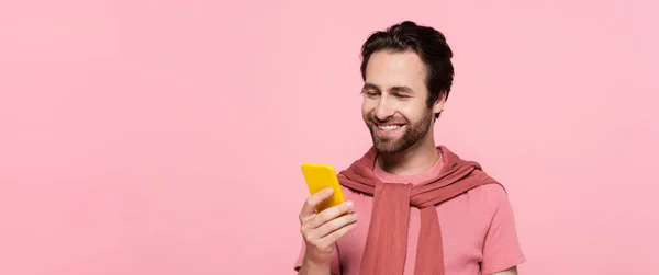 Young Brunette Man Using Yellow Smartphone Isolated Pink Banner — Stock Photo, Image