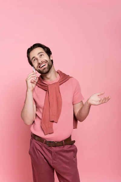 Homem Positivo Olhando Para Cima Enquanto Fala Smartphone Isolado Rosa — Fotografia de Stock