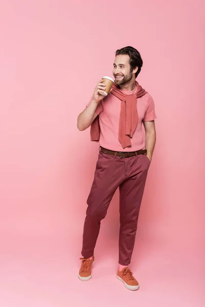 Χαμογελώντας Άνθρωπος Takeaway Ποτό Κρατώντας Χέρι Στην Τσέπη Ροζ Φόντο — Φωτογραφία Αρχείου