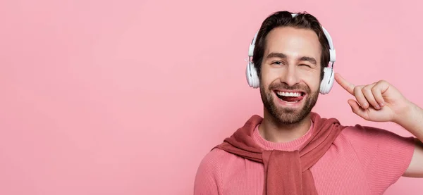 Homem Sorridente Fones Ouvido Piscando Furando Língua Isolada Rosa Banner — Fotografia de Stock