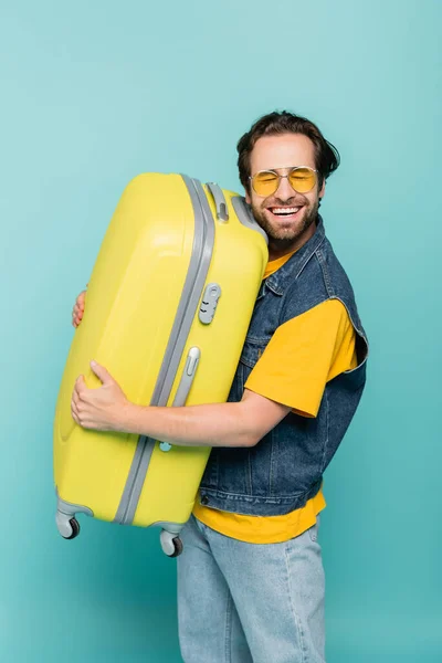 Happy Man Sunglasses Hugging Suitcase Isolated Blue — Stock Photo, Image