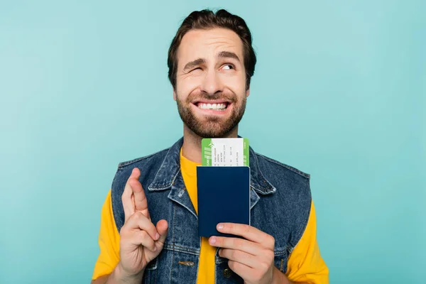 Hombre Con Pasaporte Billete Avión Mientras Cruza Dedos Aislados Azul —  Fotos de Stock