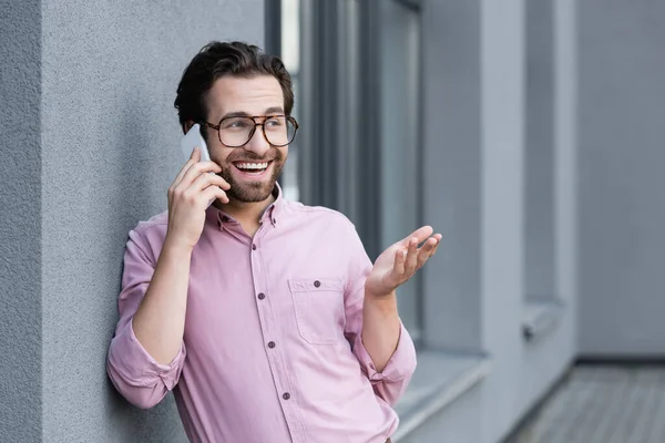 Wesoły Biznesmen Rozmawiający Przez Telefon Komórkowy Pobliżu Budynku — Zdjęcie stockowe