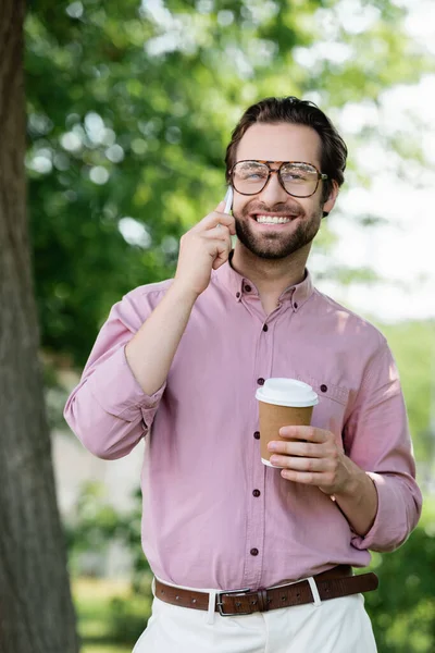 Joven Empresario Sosteniendo Taza Papel Hablando Teléfono Inteligente Aire Libre — Foto de Stock