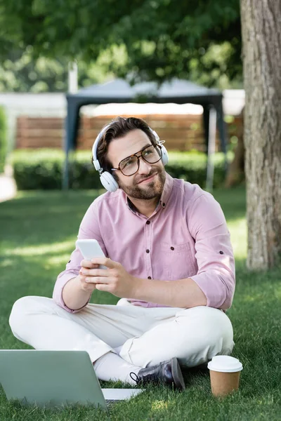 Homem Negócios Sonhador Fones Ouvido Usando Gadgets Perto Copo Papel — Fotografia de Stock