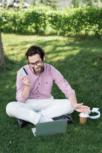 Smiling Businessman Credit Card Having Video Call Laptop Headphones Takeaway — Stock Photo, Image