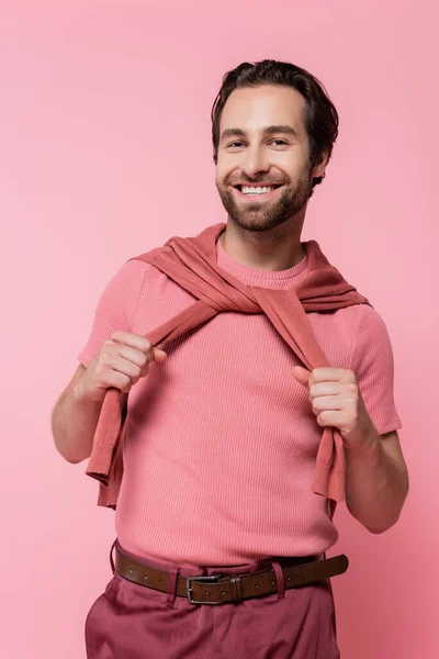 Fröhlicher Mann Hält Pullover Auf Schultern Isoliert Auf Pink — Stockfoto