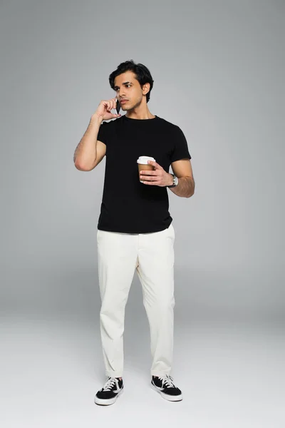 Full Length Young Man Holding Coffee Talking Smartphone Grey — Stock Photo, Image