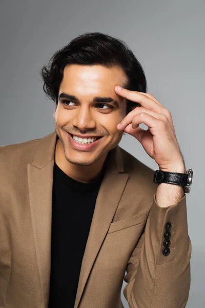 stock image portrait of happy young man in blazer looking away isolated on grey