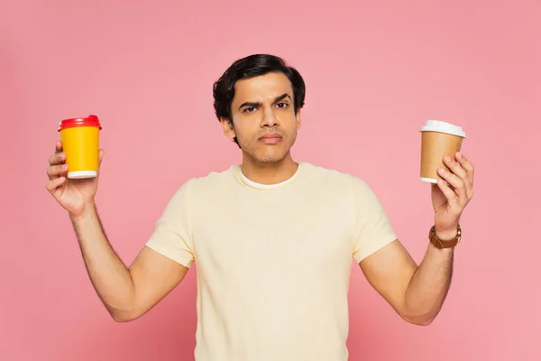 Confused Man Choosing Paper Cups Isolated Pink — Stock Photo, Image