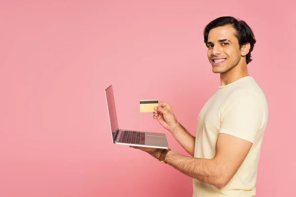 Joven Hombre Alegre Con Tarjeta Crédito Portátil Aislado Rosa — Foto de Stock