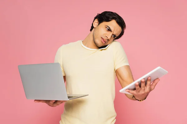 Busy Young Man Talking Smartphone While Holding Gadgets Isolated Pink — Stock Photo, Image