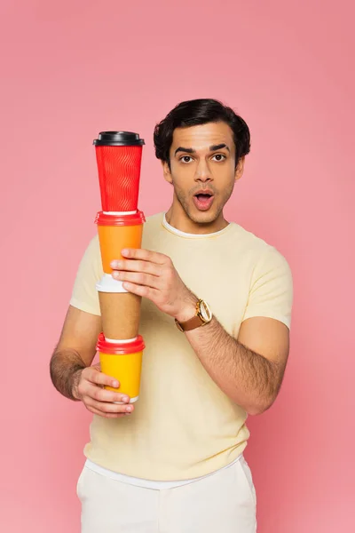 Shocked Young Man Holding Stacked Paper Cups Isolated Pink — Stock Photo, Image