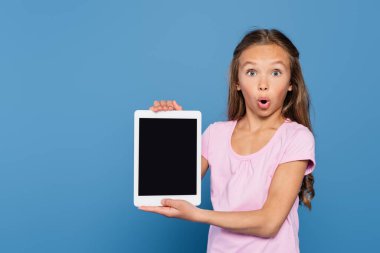 Elinde mavi ekranlı dijital tablet tutan hayrete düşmüş çocuk. 