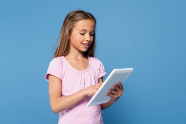Mavi üzerine izole edilmiş dijital tablet kullanan pozitif çocuk 