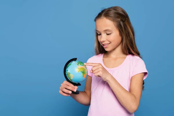 Criança Alegre Apontando Para Globo Isolado Azul — Fotografia de Stock