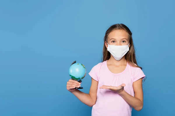 Schoolgirl Medical Mask Pointing Globe Isolated Blue — Foto de Stock