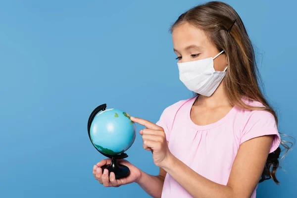 Preteen Schoolgirl Medical Mask Pointing Globe Finger Isolated Blue — Stock Photo, Image