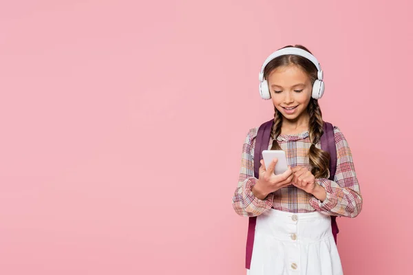 Glimlachend Schoolkind Koptelefoon Met Behulp Van Mobiele Telefoon Geïsoleerd Roze — Stockfoto