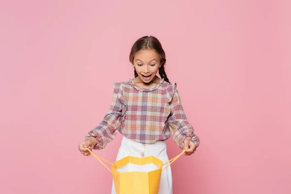 Criança Surpreso Blusa Xadrez Olhando Para Saco Compras Amarelo Isolado — Fotografia de Stock