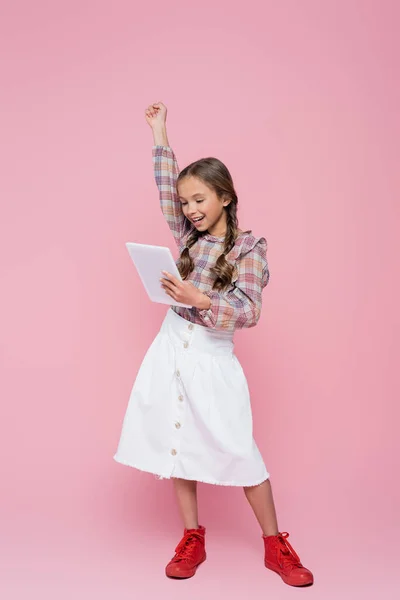 Fröhliches Mädchen Zeigt Triumphgeste Während Digitales Tablet Auf Rosa Hintergrund — Stockfoto