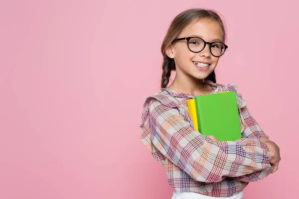 一个快乐的女孩 带着课本 对着用粉色隔离的相机微笑 — 图库照片