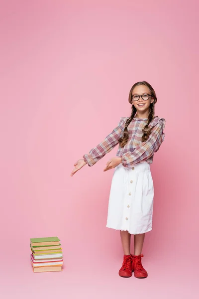 Girl White Skirt Plaid Blouse Pointing Stack Books Pink Background — Stock Photo, Image