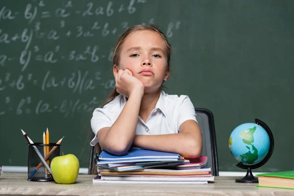 Upset Schoolgirl Looking Camera Notebooks Globe Chalkboard Blurred Background —  Fotos de Stock