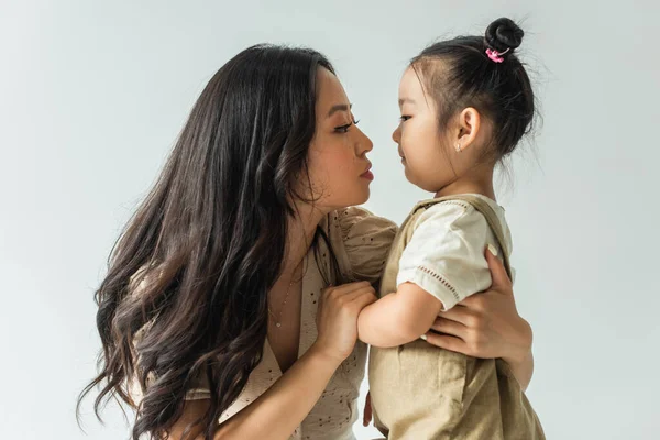 Side View Stylish Asian Mother Hugging Toddler Daughter Isolated Grey — Stock Photo, Image