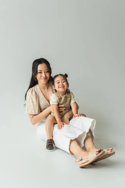 Comprimento Total Alegre Asiático Mãe Sentado Com Criança Filha Cinza — Fotografia de Stock